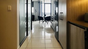 Una cocina moderna con piso de baldosas brillantes, armarios de madera y un comedor con mesa y sillas.