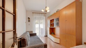 A room with a bed, a wooden wardrobe, a window with curtains, and a ceiling light fixture. - Apartment "A due passi dal mare" with Mountain View, Balcony & Wi-Fi (Pietra Ligure)