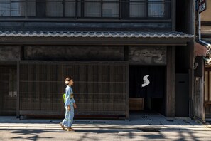 Ein traditionelles japanisches Gebäude mit einem Ziegeldach und einer großen Holztür.