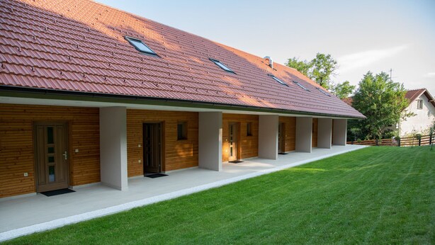 A modern building with a tiled roof, multiple doors, and a well-maintained lawn. - Hocka Koca (Hoce-Slivnica)
