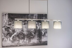 A modern light fixture with three square panels and a horizontal bar.