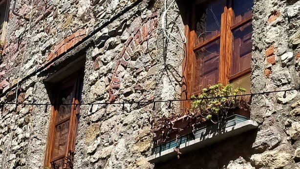 A stone building with two windows, each with wooden shutters and a balcony with potted plants. - Holiday Home 'Casa Annamaria' (Arcola)