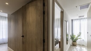 A modern hotel room with wooden flooring, a large mirror, and a potted plant. - Líbere Pamplona Yamaguchi (Pamplona)