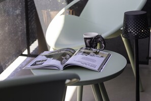 Una mesa con una revista, una taza y un adorno.