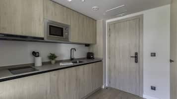 A modern kitchen with wooden cabinets, a stainless steel microwave, a sink, and a coffee maker.