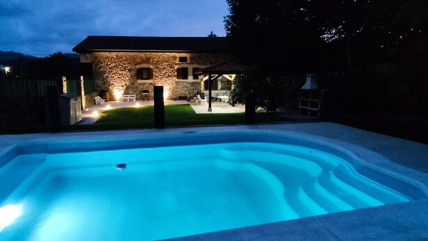 A swimming pool with a stone building in the background.