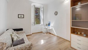 A room with a bed, a desk, a chair, a bookshelf, a window, and a clock on the wall. - Pet-Friendly Apartment 'La Colombera' with Sea View, Garden & Wi-Fi (Alassio)