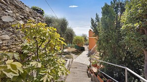 A stone wall, a staircase, and greenery. - Pet-Friendly Apartment 'La Colombera' with Sea View, Garden & Wi-Fi (Alassio)