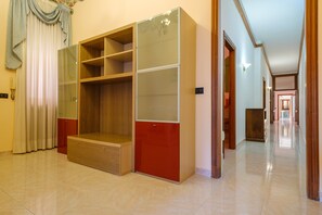 A room with a built-in wardrobe, a wooden bench, and a tiled floor.