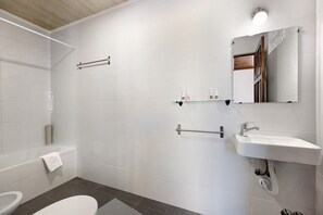 Un baño moderno con bañera, inodoro, lavabo y toallero.
