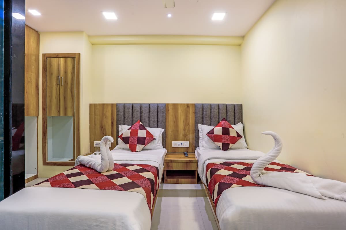 A hotel room with two beds, wooden headboards, and a mirror.