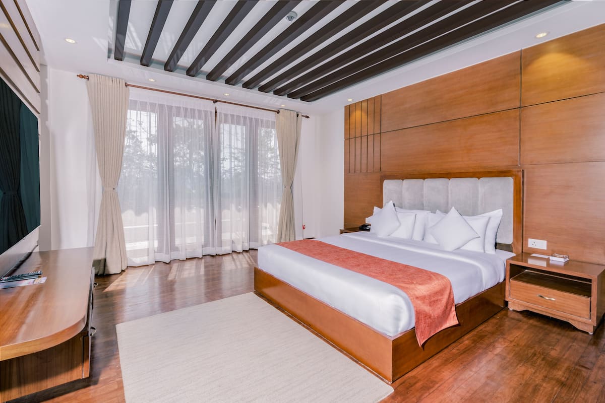 Un dormitorio moderno con una cama grande, cabecera de madera y una mesita de noche de madera.