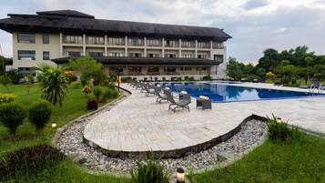 Ein Hotel mit Schwimmbad, Außenbereich und einem gepflegten Garten.