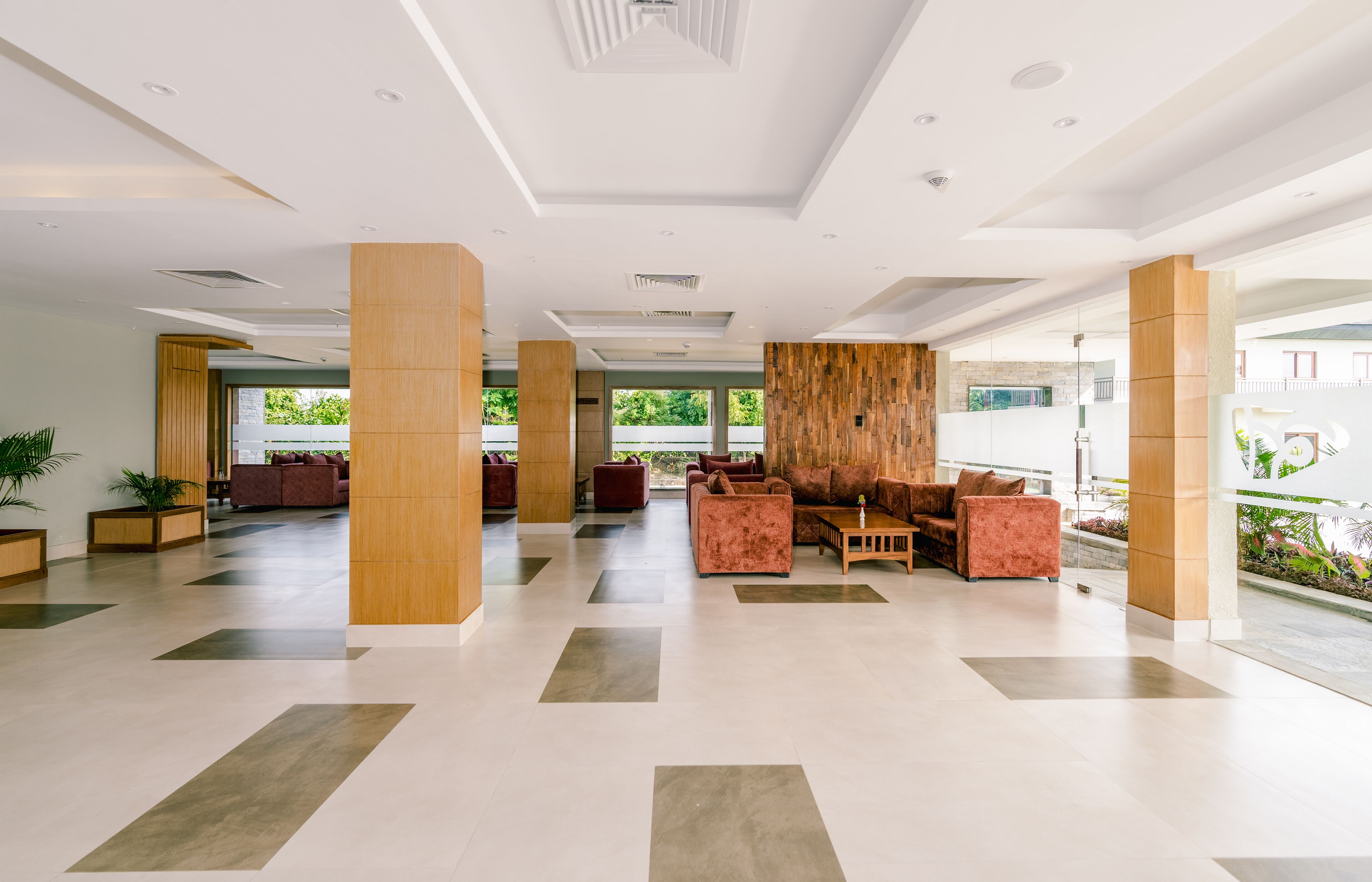 A spacious lobby with a modern design, featuring a mix of seating areas and a large wooden column.
