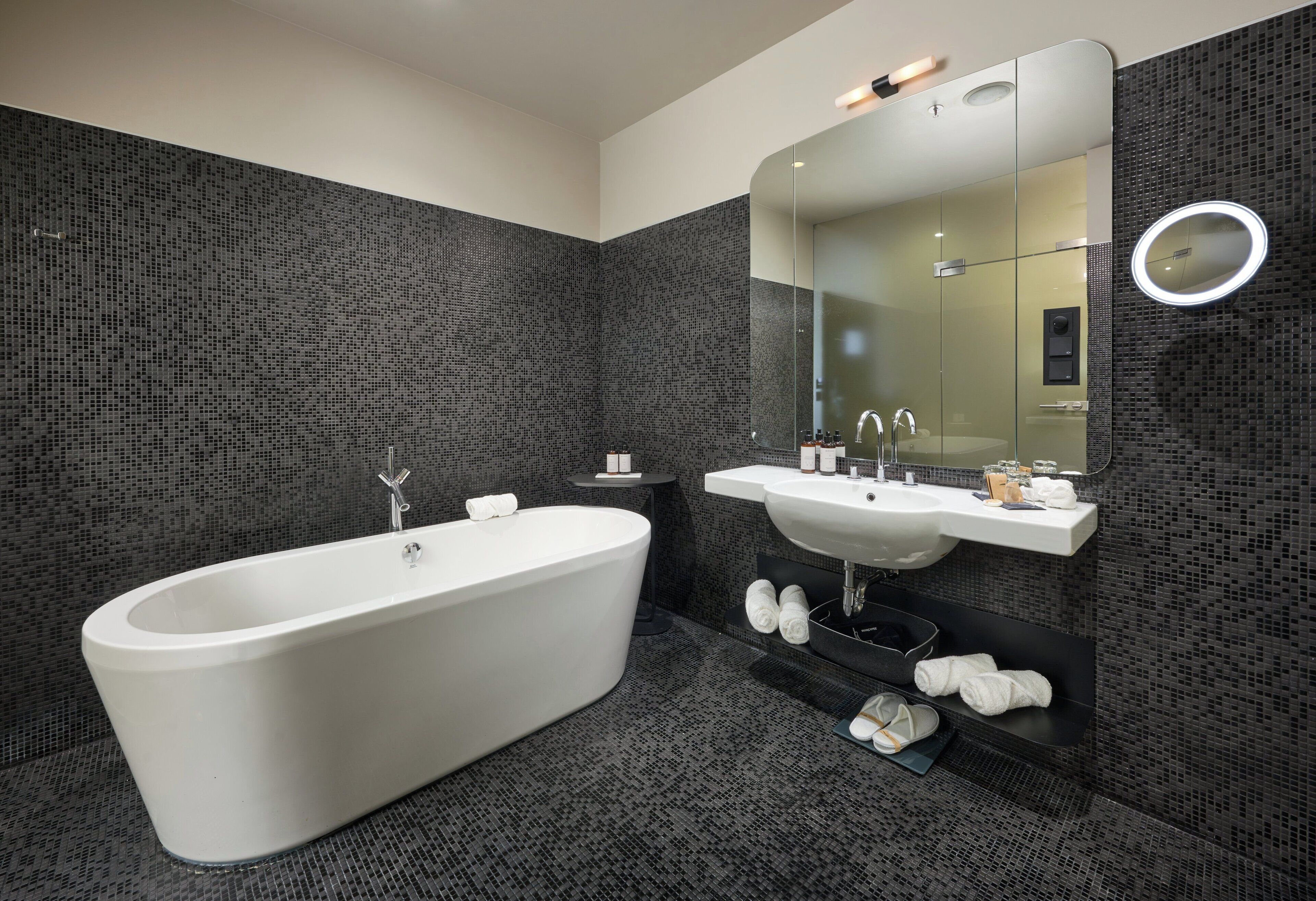Un baño moderno con una bañera independiente, un tocador con espejo y una zona de ducha.