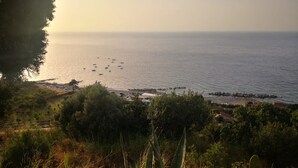 A coastal landscape with a view of the sea, boats, and a small beach area with buildings. - Spisidda House - Lipari Studio - Near Gioiosa Marea (Zappardino)