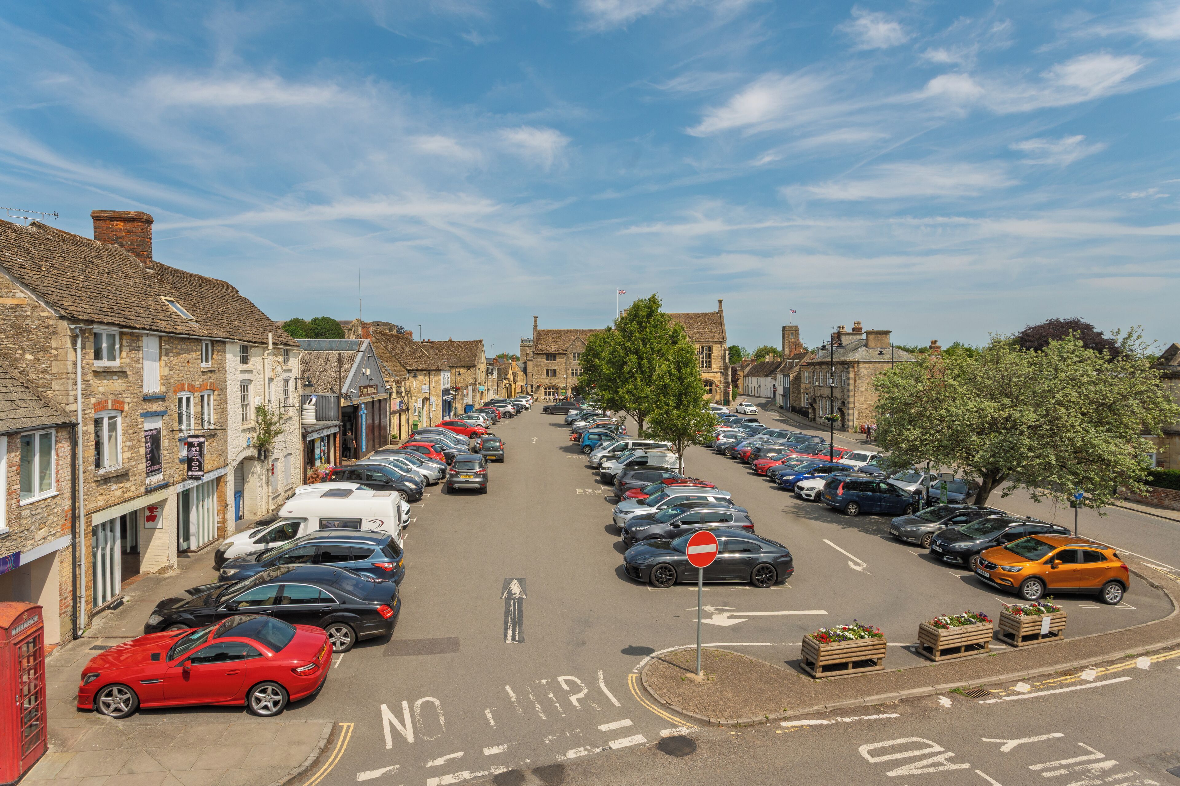 A street lined with parked cars and historic buildings.