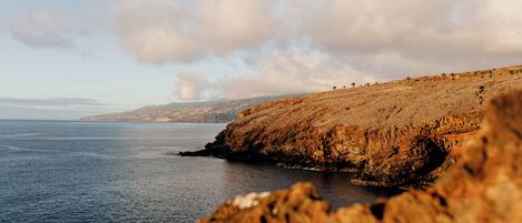 A coastal landscape with rocky terrain and a body of water.