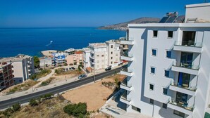 Zona costera urbana con edificios modernos, una carretera y vista al mar.