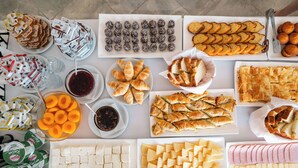 Una variedad de alimentos, como pasteles, queso y pan, dispuestos sobre una mesa.