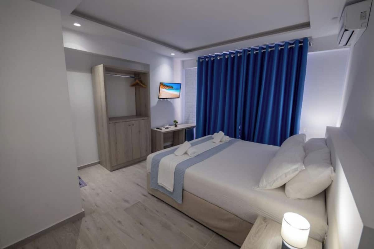 Ett hotellrum med en säng, en TV, ett skrivbord och en garderob.
