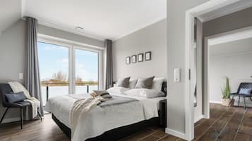 Une chambre moderne avec un grand lit, une chaise et une vue sur l’extérieur.