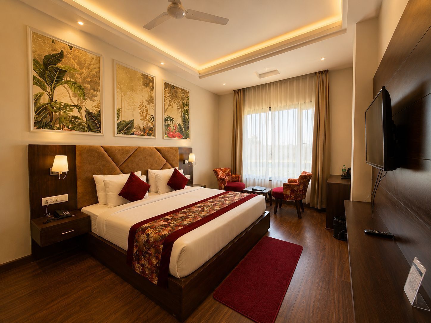 A hotel room with a large bed, a TV, a desk, and a chair.