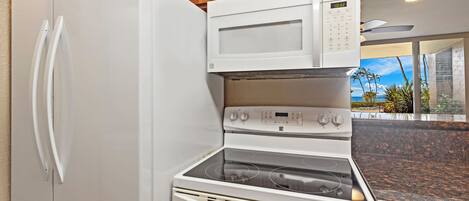 Une cuisine équipée d’un réfrigérateur, d’un four à micro-ondes, d’une cuisinière et d’un four.