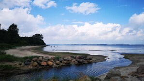 A coastal landscape with a rocky shoreline, a small stream, and a distant view of the sea. - Apartment "PASTORATSGARTEN SCHLEI": Relax and enjoy (Norderbrarup)
