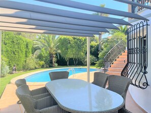A covered outdoor area with a pool, wicker furniture, and a staircase. - T-0422, Amanecer, new furnished villa with private pool (Dènia)
