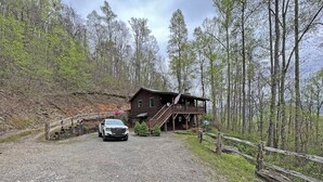 Eine Hütte mit einem Schotterweg, einer Holzterrasse und einer Treppe, die zum Eingang führt.