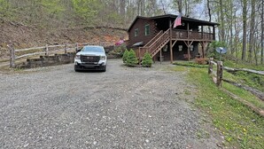 Eine Hütte mit Kiesauffahrt, einer Holzterrasse und einer Veranda mit einer amerikanischen Flagge.