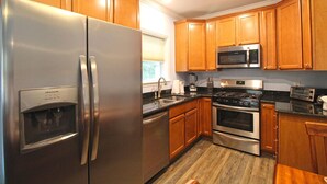 A kitchen with wooden cabinets, stainless steel appliances, a microwave, and a built-in oven.