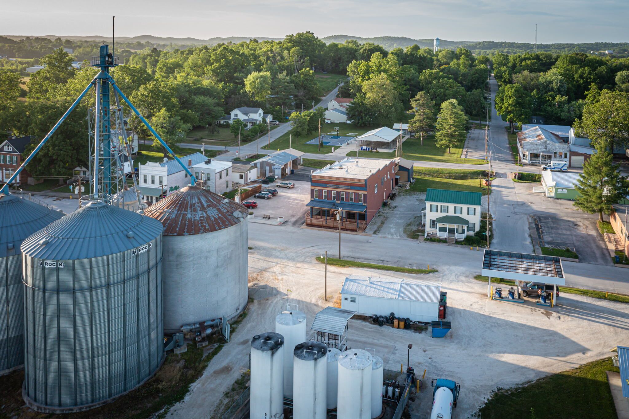 A rural town with grain silos, a water tower, and a small-town main street.