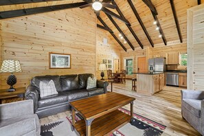 L’intérieur d’une cabane en bois comprend un salon, un coin repas et une cuisine.