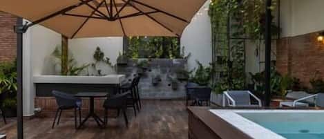An outdoor patio area with a pool, seating, and a staircase leading to a higher level.