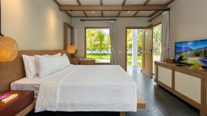 A modern hotel room with a large bed, a TV, and a view of the outdoors. - Coco Garden Resort Phu Quoc (Phu Quoc)