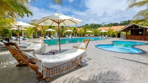 A poolside area with lounge chairs, umbrellas, and a pool. - Coco Garden Resort Phu Quoc (Phu Quoc)