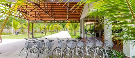 A covered outdoor area with a row of bicycles parked under a wooden roof.