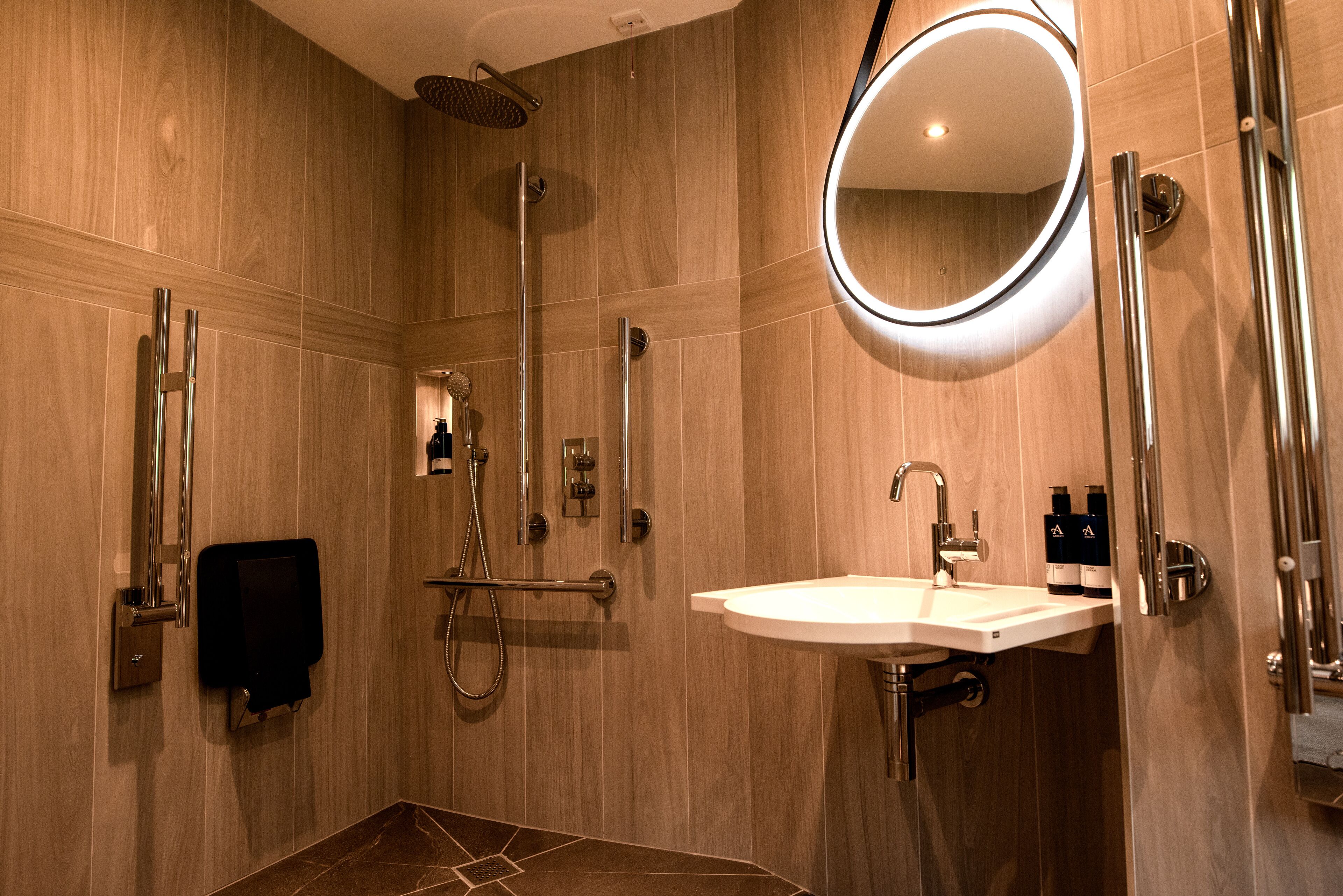 A modern bathroom with a shower, sink, and mirror.