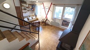 A spacious living area with a staircase, a sofa, a dining table, and a fireplace. - Apartamento en La Molina, Grandes Vistas, Chimenea (La Molina, Alp)