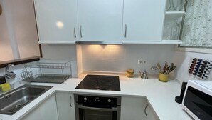 A modern kitchen with white cabinets, a built-in oven, a microwave, and a stove. - Apartamento en La Molina, Grandes Vistas, Chimenea (La Molina, Alp)