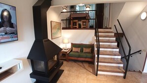 A living room with a fireplace, a sofa, a lamp, and a staircase. - Apartamento en La Molina, Grandes Vistas, Chimenea (La Molina, Alp)