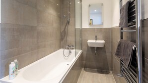 A modern bathroom with a glass-enclosed shower, a white sink, and a towel rack. - Bernard Point (Southampton)