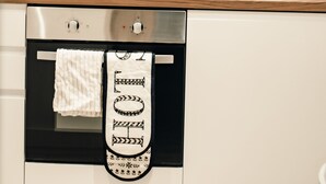 A kitchen with a built-in oven, a coffee maker, and a towel hanging on the oven door.