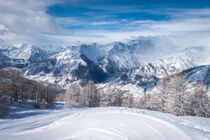 Eine verschneite Berglandschaft mit einer Skipiste.
