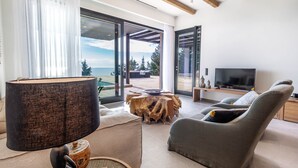 Una sala de estar moderna con un ventanal grande, un sofá, un televisor y una mesa de centro de madera.