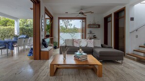 Ein modernes Wohnzimmer mit Couch, Esstisch und Stühlen sowie einem Holztisch.