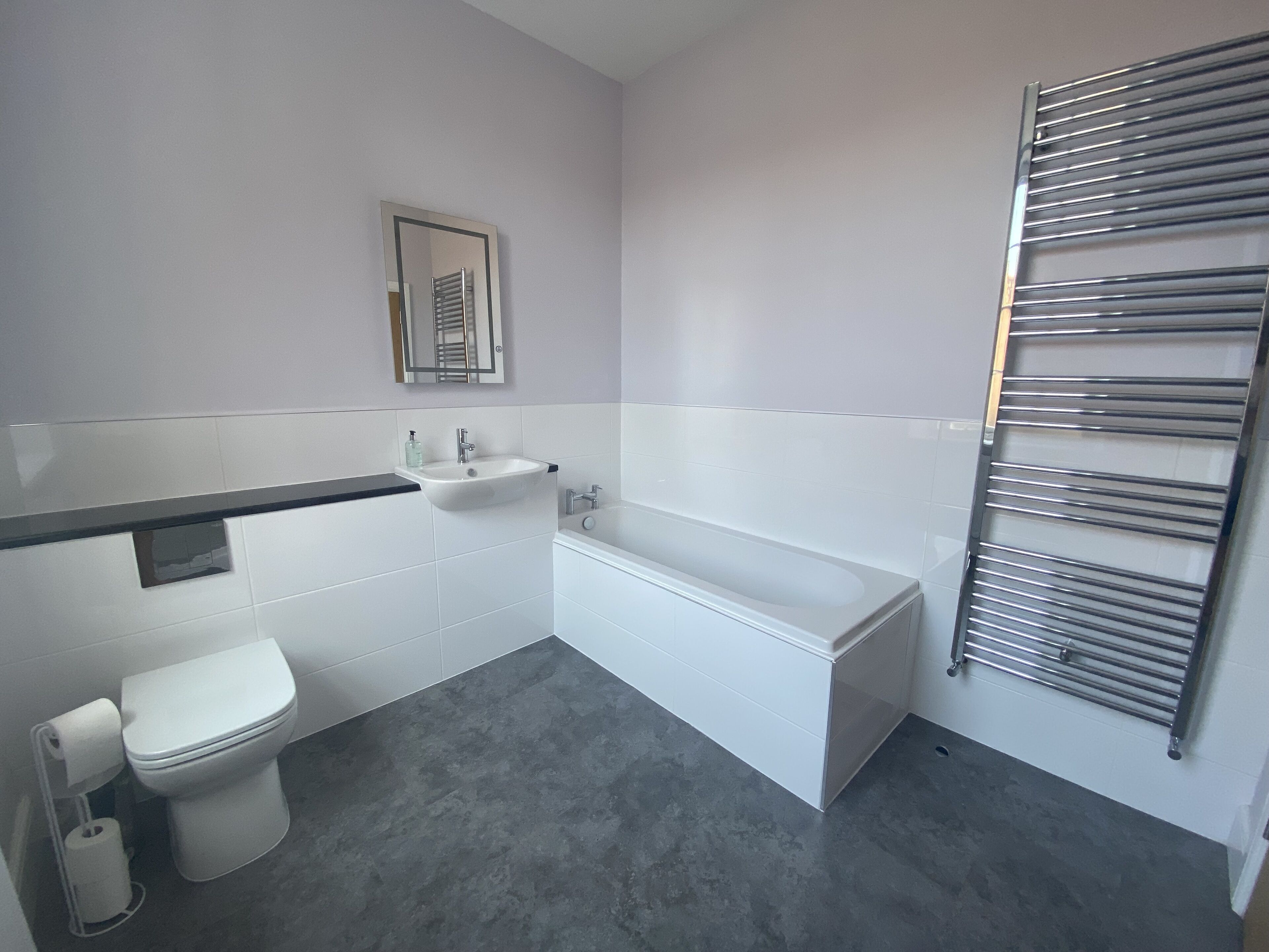 Un baño moderno con inodoro, lavamanos y bañera.