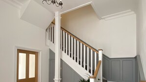 A staircase with white railings and a dark carpeted landing. - Red Barns Bed & Breakfast (Redcar)